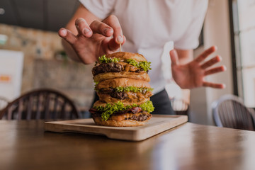 triple hamburguesa con queso cheddar con un palillo en un restaurante