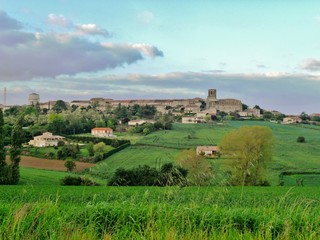 Fototapeta na wymiar Fotografía de una típica estampa de la idílica región de la Dordogna francesa con un pequeño pueblo rodeado de diferentes tonos de color verde de la naturaleza.