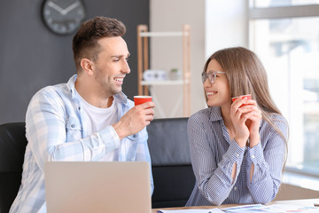 Young colleagues drinking coffee in office