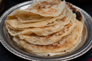 Indian layered flaky bread paratha on silver plate