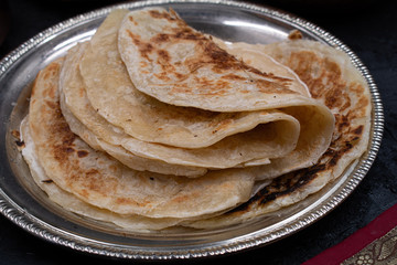Indian layered flaky bread paratha on silver plate