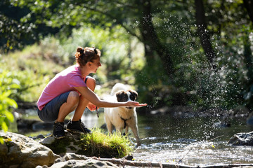 Woman and her dog in the summer river.