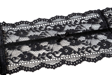 Close-up of black see-through lace ribbon with a small bowtie, detail of a sexy garter or suspender...