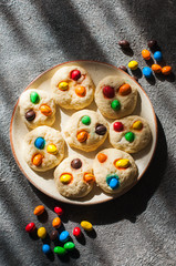 Homemade cookies with colorful candies. Grey background.