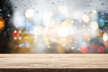 Empty wooden desk space and blurry background of bokeh light for product display montage.