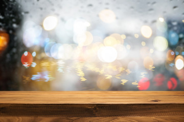 Empty wooden desk space and blurry background of bokeh light for product display montage.