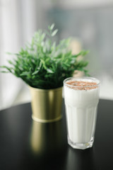 milkshake with chocolate chips on a background of black table and greenery