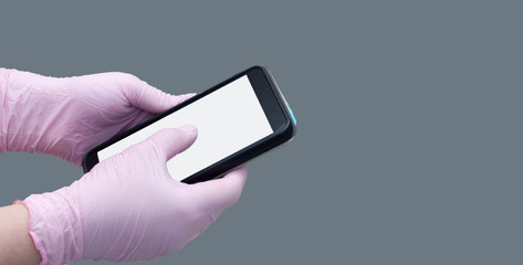 Hands in pink medical gloves holding smartphone on isolated background. Blank screen. Copy space. Mock up.