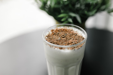 milkshake with chocolate chips on a background of black table and greenery