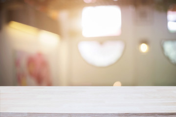 Empty wooden desk space and blurry background of restaurant vintage tone for product display montage.