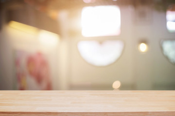 Empty wooden desk space and blurry background of restaurant vintage tone for product display montage.