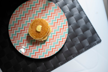 Dessert sweet carb pancake. Multi layer pancake with butter and sweet honey. Vintage pastel plate serve for after lunch break