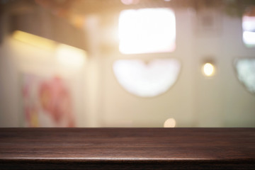 Empty wooden desk space and blurry background of restaurant vintage tone for product display montage.