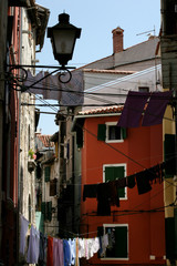 Fototapeta na wymiar Old narrow street with laudry drying up on ropes