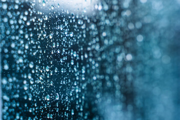 Naklejka na ściany i meble Natural water drop on glass. Selective focus. Rainy city background