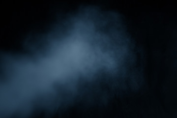 Blue clouds of smoke vapor isolated on a black background. The magic effect can be used when applying and changing