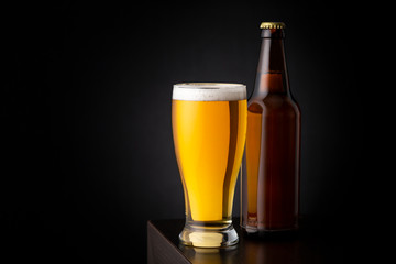 Beer bottle and a glass of cold beer on bar counter