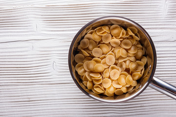 traditional italian pasta in a metal pan on a wooden background
