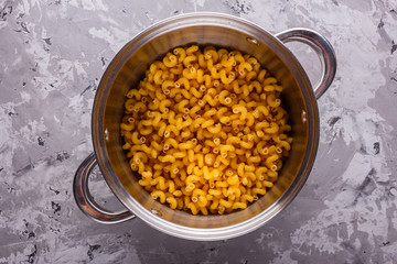 Traditional Italian pasta in a metal pan on a stone background