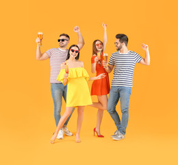 Happy young people with alcoholic drinks on color background