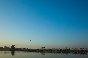 Famous U-Bein bridge on horizon on Taung Tha Man Lake. Amarapura, Mandalay, Myanmar