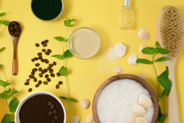 natural organic ingredients-sea salt, coffee scrub, honey and a hard body brush on a yellow background. home skin care for cellulite. concept of skin care, home Spa. the view from the top.