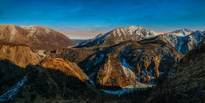 Siberian autumn beautiful landscape with the Eastern Sayan Mountains. Yellowed trees are reflected in the Irkut River. Baikal region, Buryatia, Tunka Valley