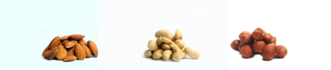 Three piles of nuts - hazelnut, almond, cashew isolated on white background. Image contains copy space