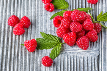 juicy fresh natural raspberries on a gray wooden rustic background
