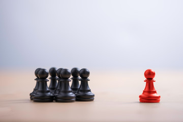 Red pawn chess stepped out of group to show different thinking ideas and leadership. Business...