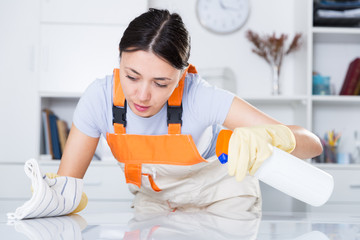 Young  woman wearing uniform cleaning table at office