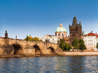 View of the Charles bridge over the Vltava river, the bridge tower and the church of St. Francis of...