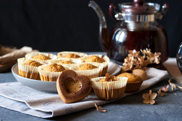 dark photo of carrot muffins and tea pot