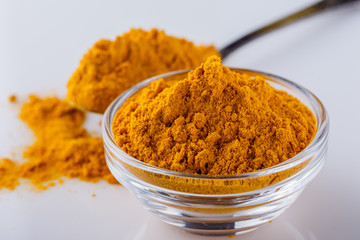 natural turmeric powder on white acrylic background