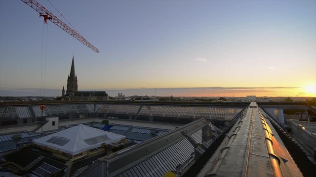 Une grue de chantier reprend le travail au lever du jour sur les toits de la vielle ville de Nantes 