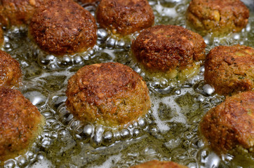 Falafel balls of seasoned chickpeas are fried in oil.