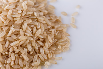 raw brown rice on white acrylic background