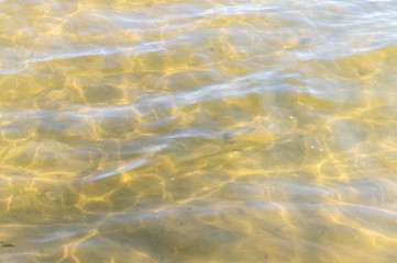 Fototapeta na wymiar Golden sandy seashore with clear water