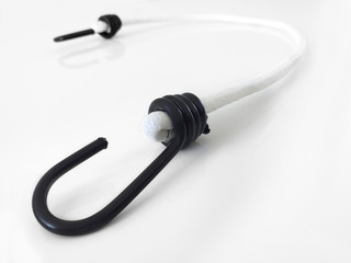 Aerial view of black hook with white strap isolated on white background. Elastic with black hook to hold objects.