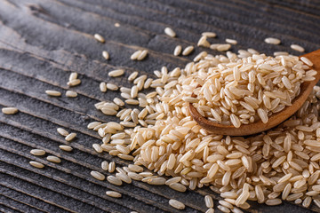 Obraz premium raw brown rice on dark rustic wooden background