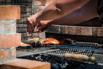 Hand seasoning the fish and the roasted octopus