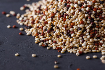 mix of quinoa grains on a dark stone background