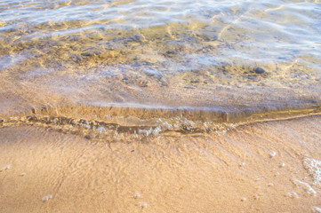 Golden sandy seashore with transparent wave