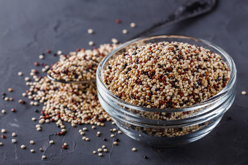 mix of quinoa grains on a dark stone background