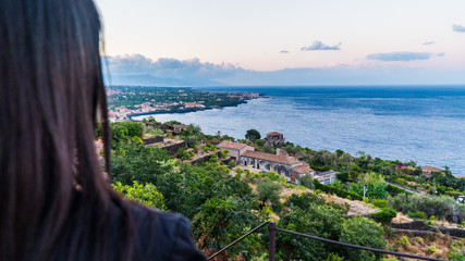 Girl looking at sunset and horizon with sea and landscape