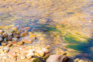 Golden mountain stream with beautiful stones and clear water