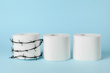 Toilet paper with barbed wire on color background. Hemorrhoids concept