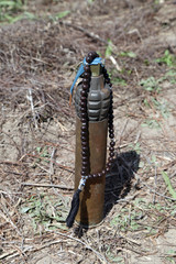 grenade, artillery shell and rosary