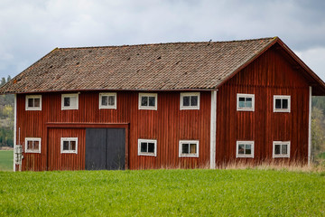 Nykoping, Sweden A red barn on a field in the spring.