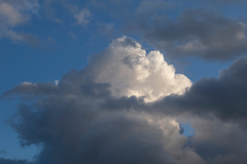 Fototapeta na wymiar white fluffy cloud in a stormy blue sky